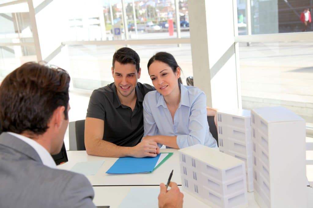 Couple In Real Estate Agency Signing Property