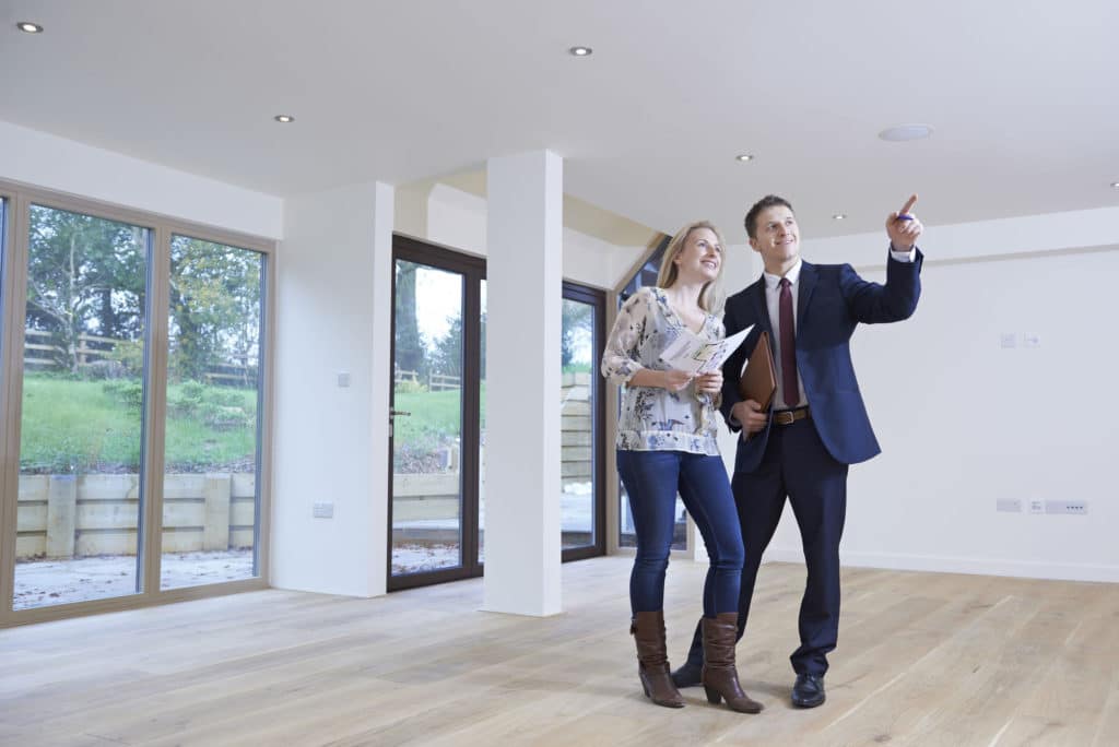 Real Estate Agent Showing Prospective Female Buyer Around Property