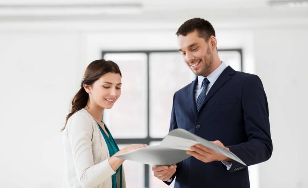 Real Estate Business Sale And People Concept Happy Smiling Realtor With Folder Showing Documents To Female Customer At New Office Room Realtor Wit